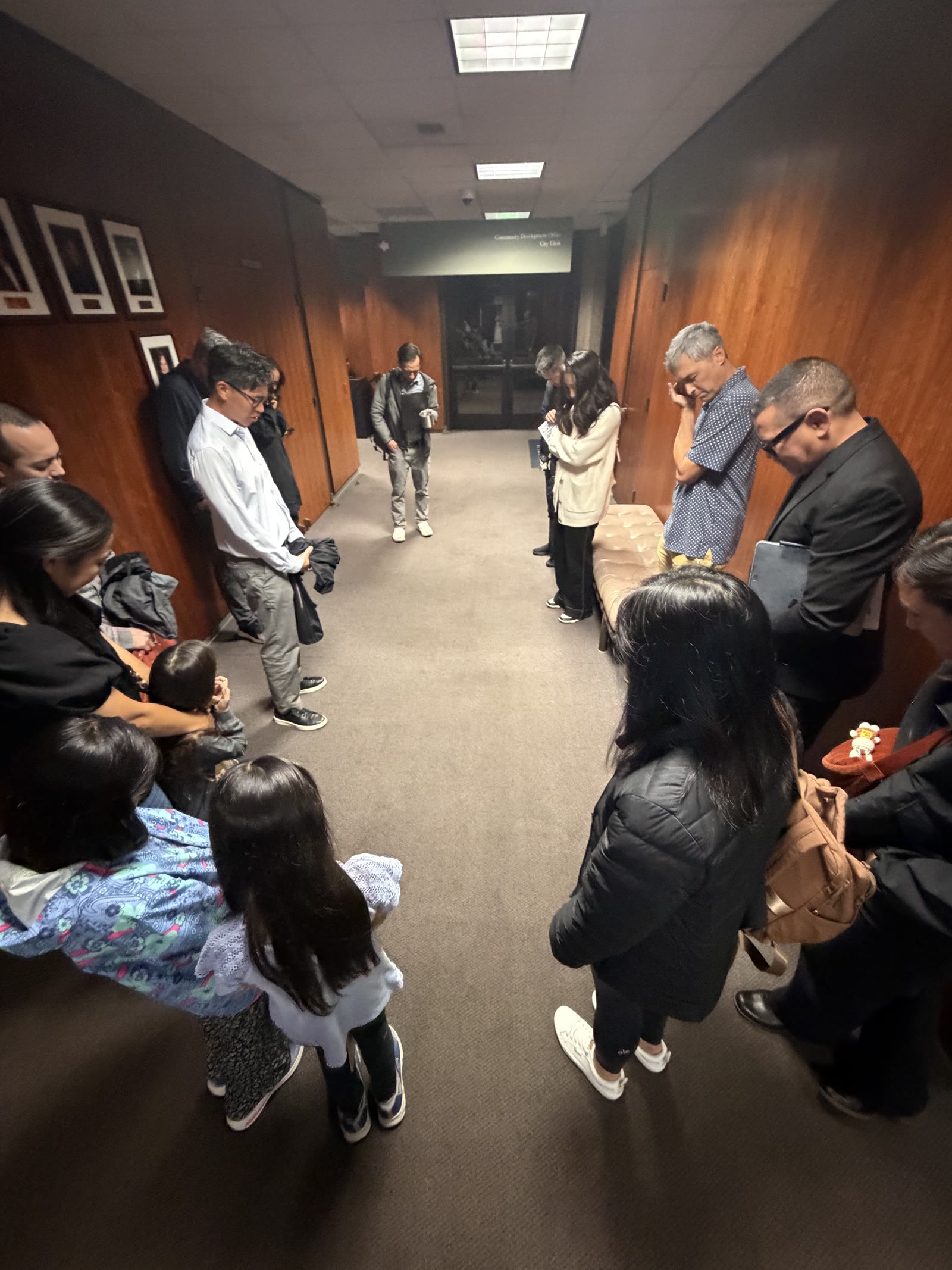 Lighthouse members praying together in the hallway after the vote